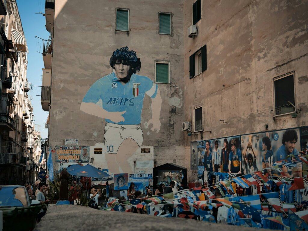 man in blue and white crew neck t-shirt standing on the street,Napoli