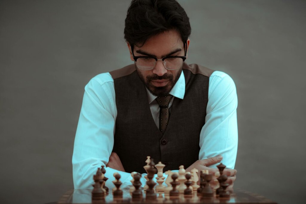 Crop thoughtful man playing chess in studio