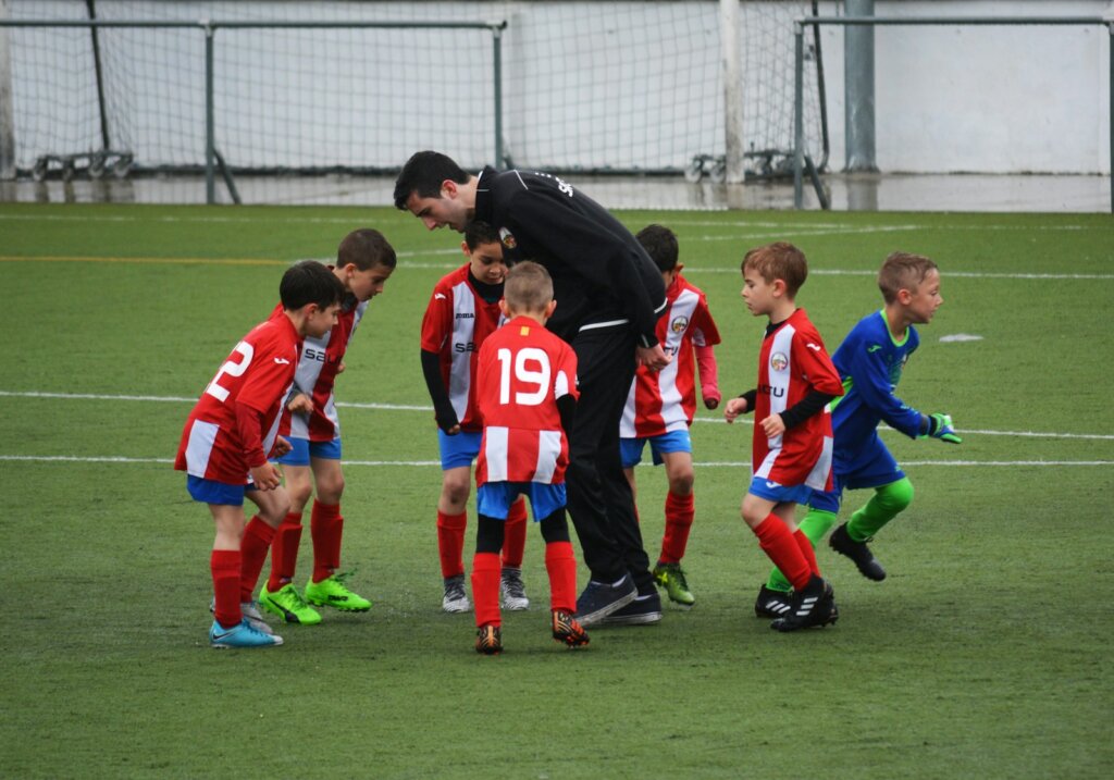 children playing soccer with coach