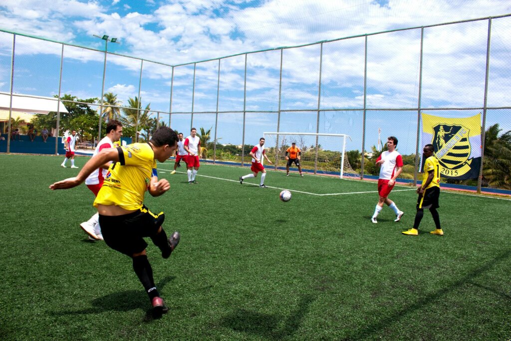 Dynamic soccer match with players in action on a bright sunny day.