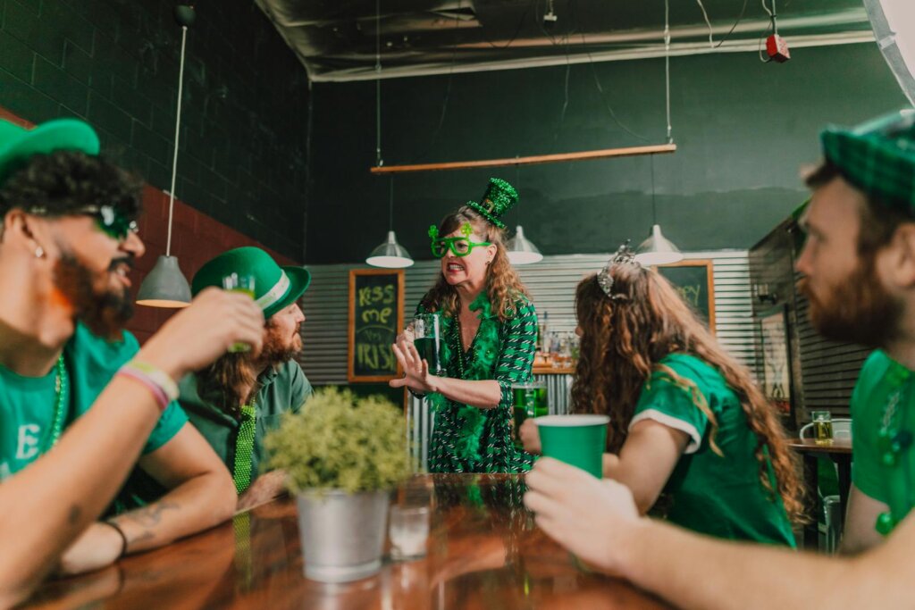 Group celebrating St. Patrick's Day at a pub wearing green attire and accessories.